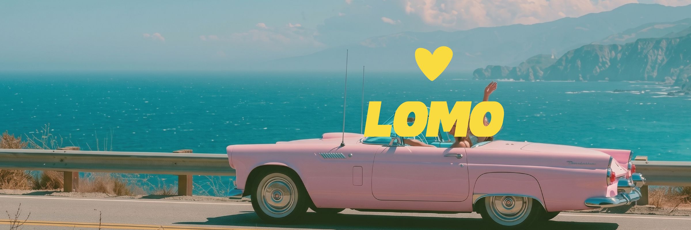 A pink convertible on a coastal highway above a turquoise ocean, the LOMO heart and wordmark in the sky.